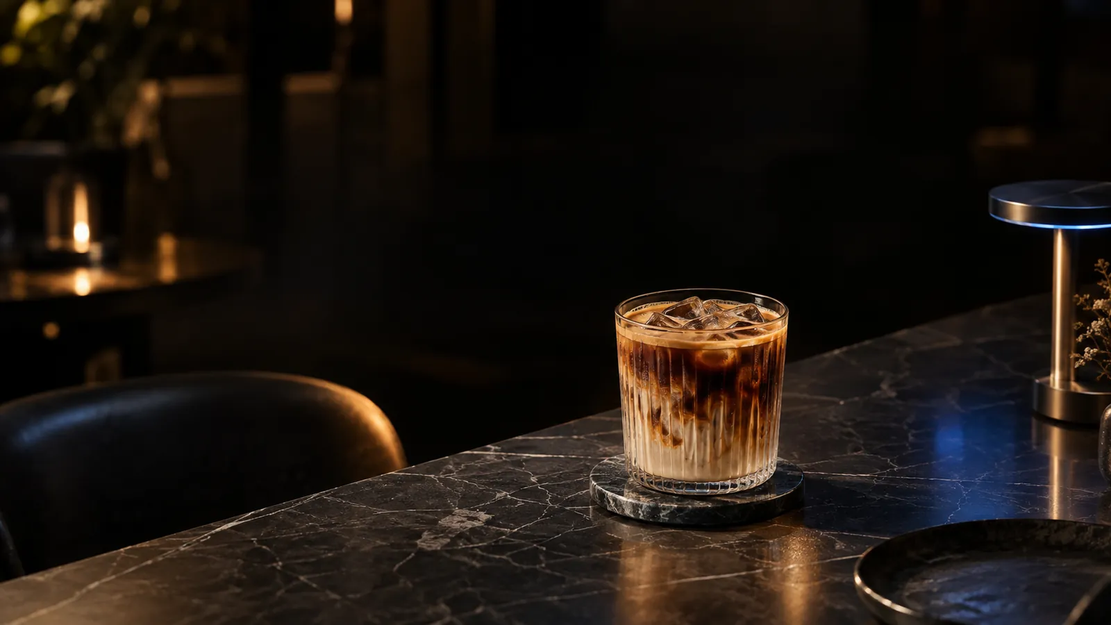An iced latte on a marble table at night